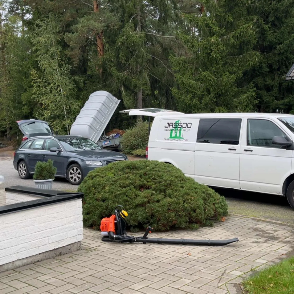 Jassoo Kiinteistöpalveluiden pakettiauto parkkeerattuna asiakkaan talon eteen jossa haravointiin lehtiä ja puhdistettiin rännit. Roskat vietiin kaatopaikalle peräkärryllä.